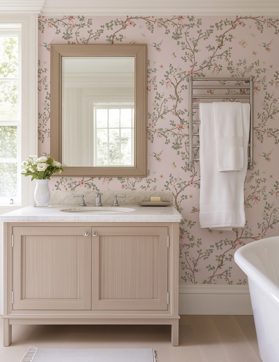 Bathroom with wooden vanity, mirror, and bathtub against a Pink Hummingbird Wallpaper – Chinoiserie Branches & Bows