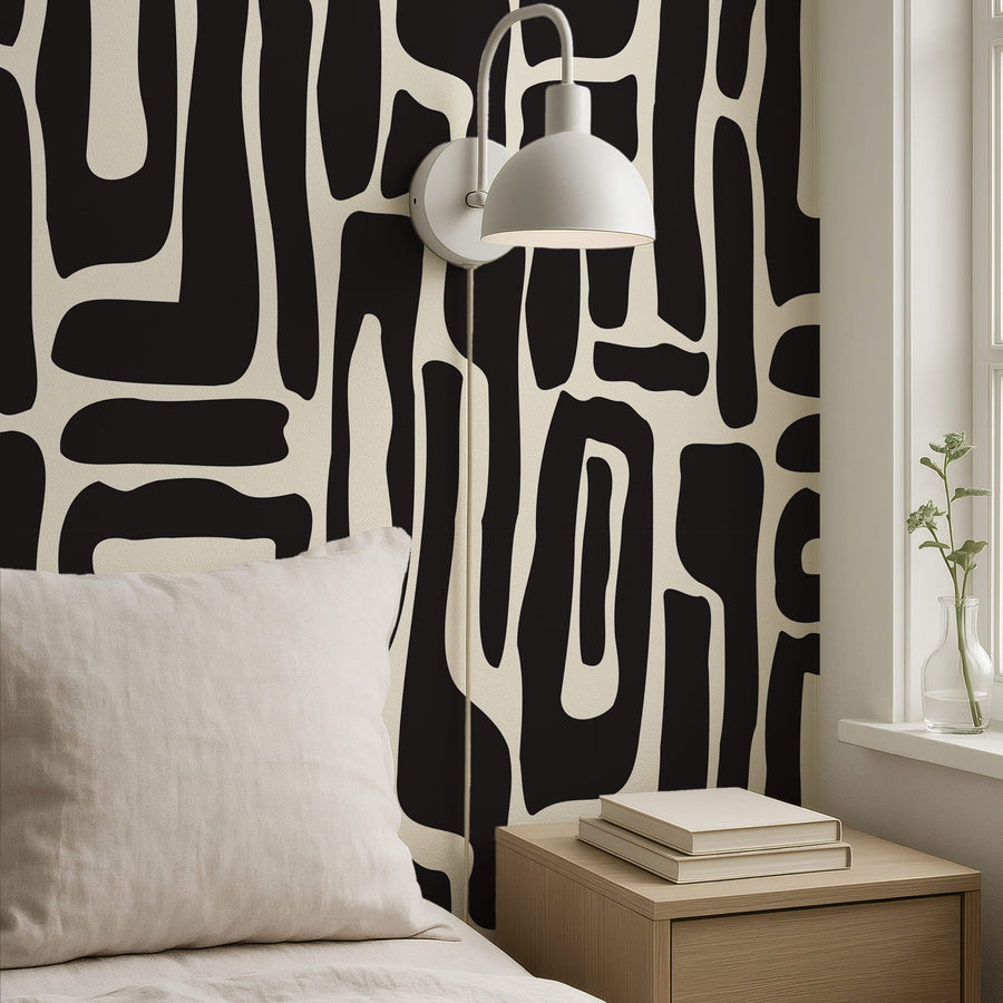 Bedroom with Modern Abstract Black and White Geometric Wallpaper white lamp, and wooden nightstand