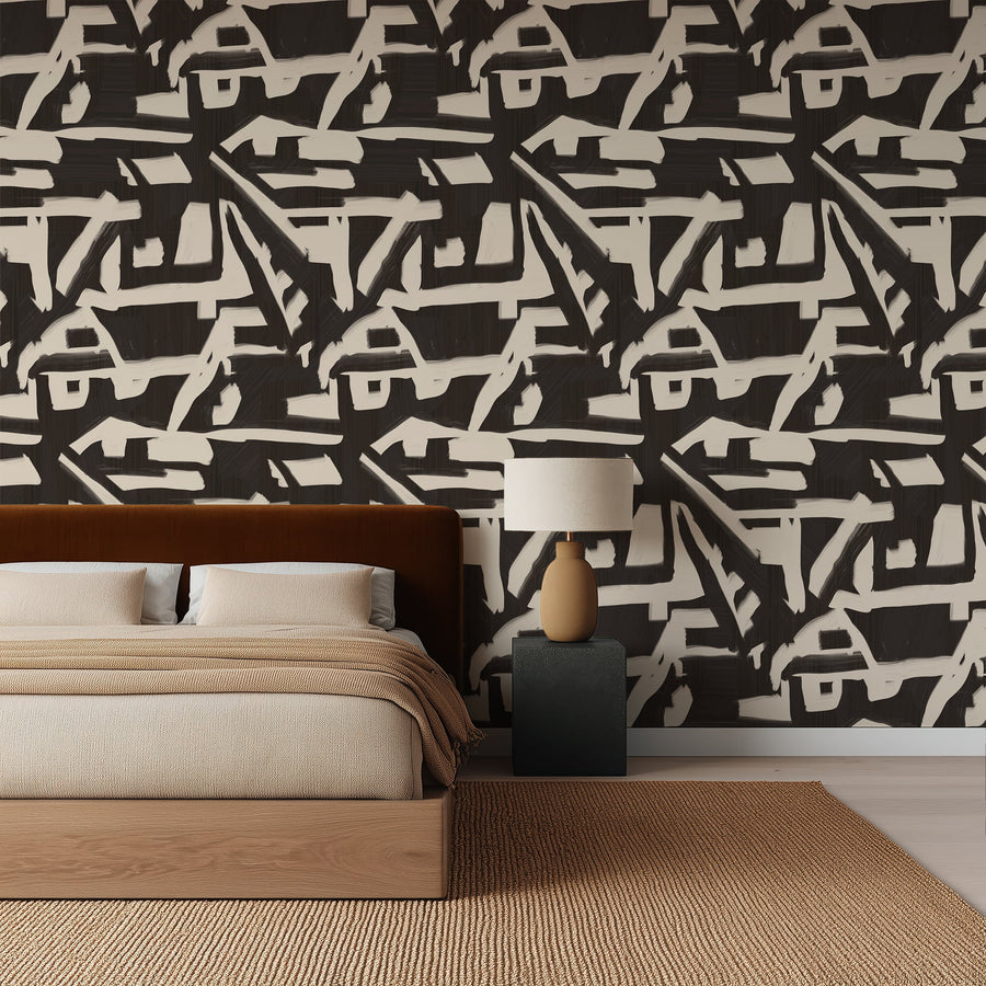 Bedroom with a black and white abstract patterned wallpaper, wooden bed, and lamp.