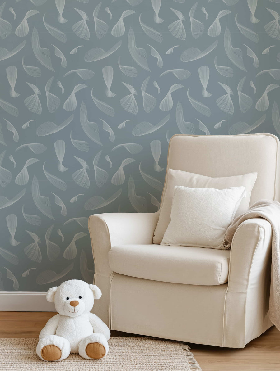 Beige armchair with white pillows against a Quill Whispers Wallpaper – Slate Blue accompanied by a white teddy bear on the floor.