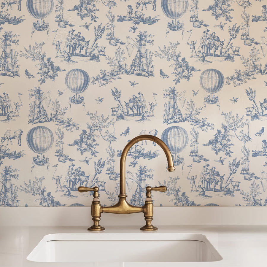 Brass kitchen faucet over a white sink with decorative Blue Watercolor Toile Wallpaper – Hot Air Balloon Pattern