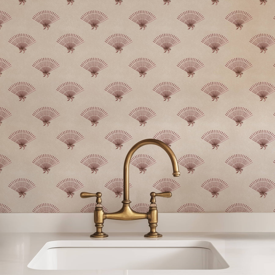 Brass sink faucet and handles on a white sink with Neutral Pink Preppy Coquette Bow Fan Wallpaper
