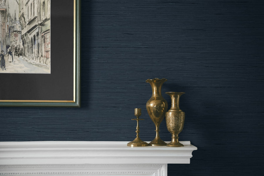Decorative vases on a white mantelpiece against a dark blue wall with framed artwork.