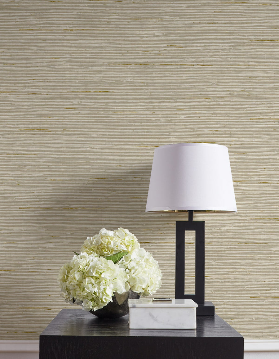 Decorative table with a lamp and flowers against a textured wall.
