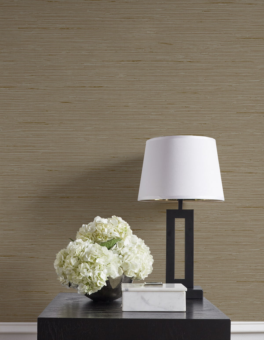 Decorative table with a lamp and flowers against a textured wall.