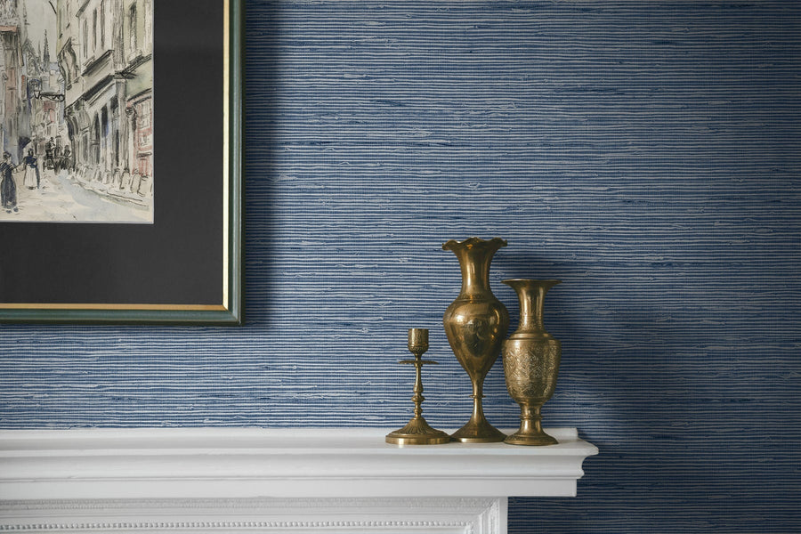 Decorative vases on a mantelpiece against a blue striped wallpapered wall.