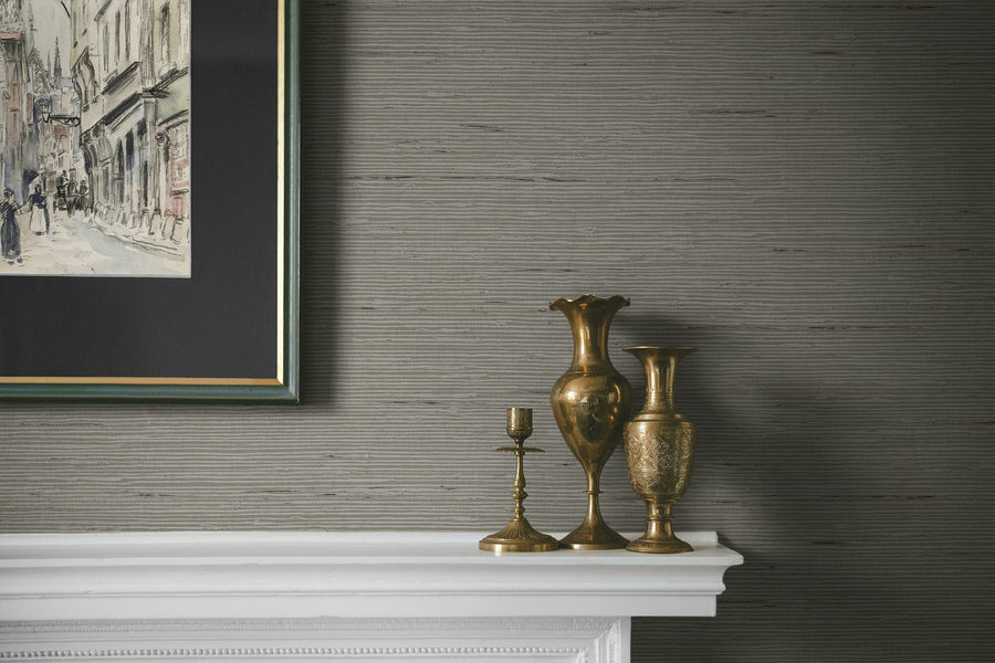 Decorative vases on a mantelpiece with a framed artwork above against a textured wall.