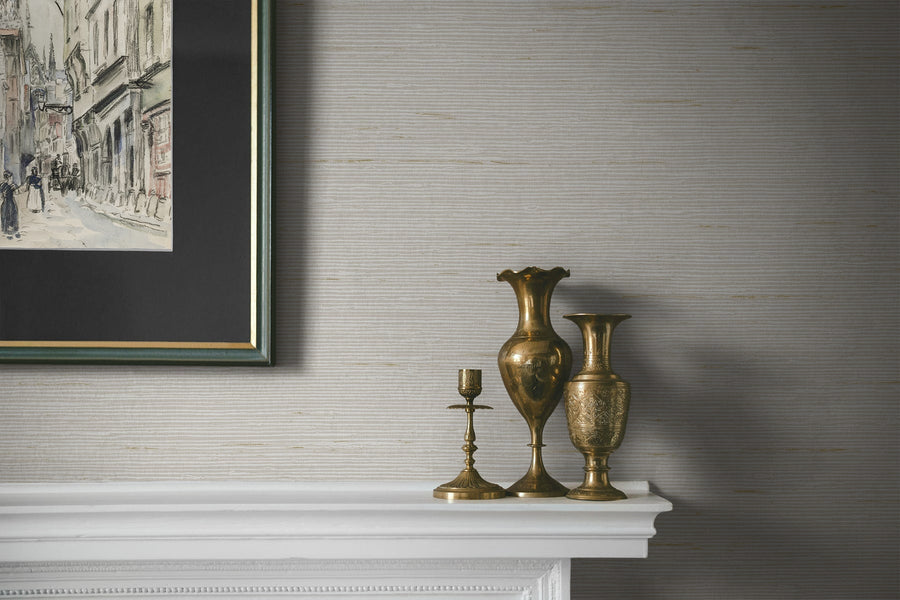 Decorative mantelpiece with gold vases and a framed painting on a textured wall.