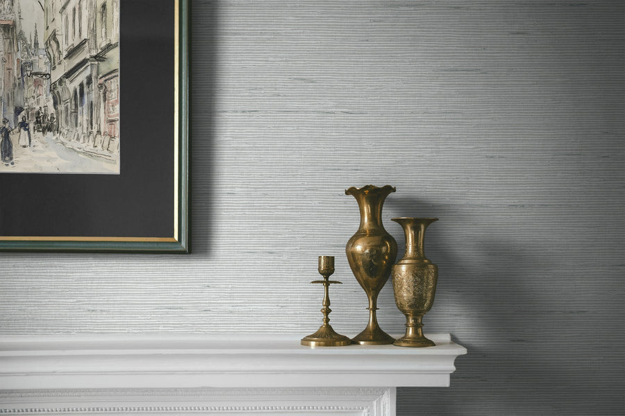 Decorative vases on a mantelpiece with a framed painting above, against a textured wall.