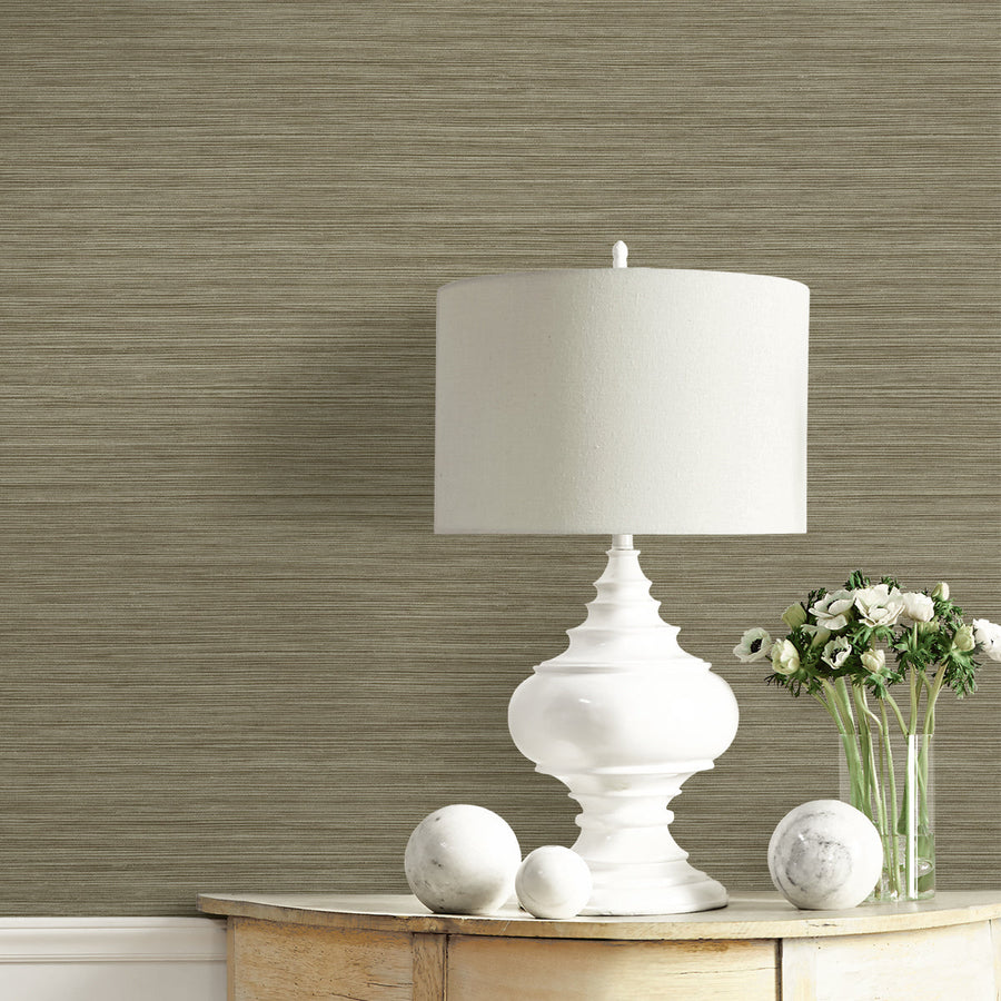 White table lamp on a wooden surface with decorative items against a textured wall.