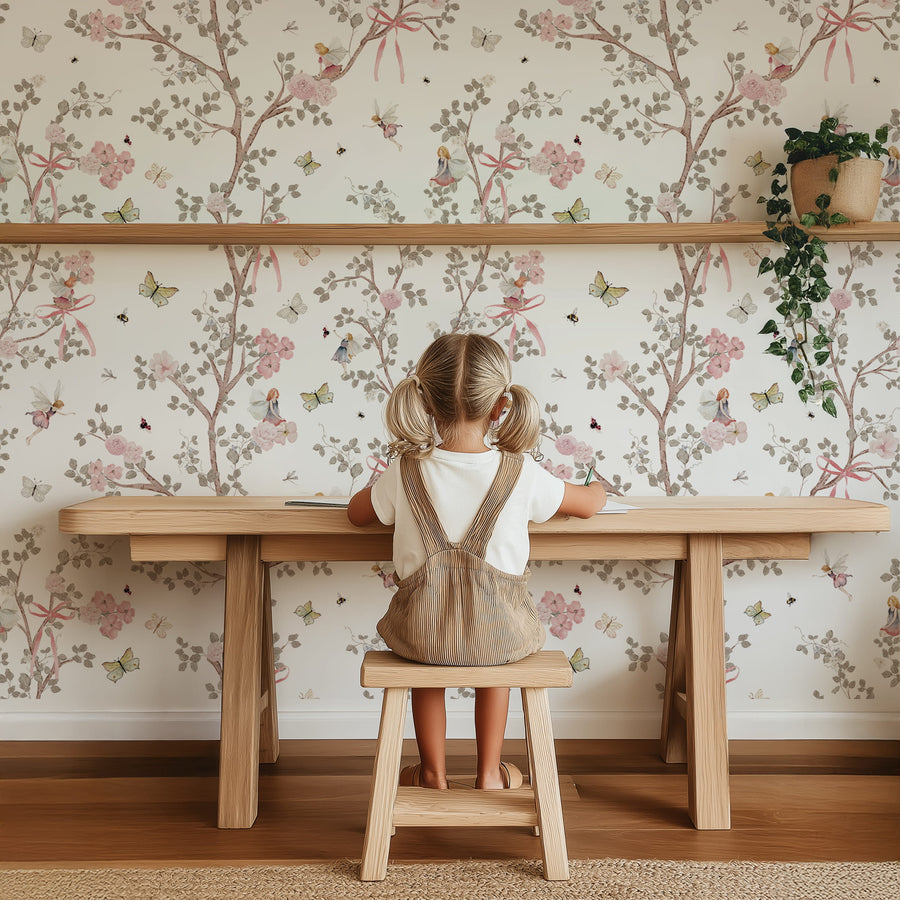 Child sitting at a wooden table with Fairy Garden Wallpaper – Pink Floral Branches & Butterflies