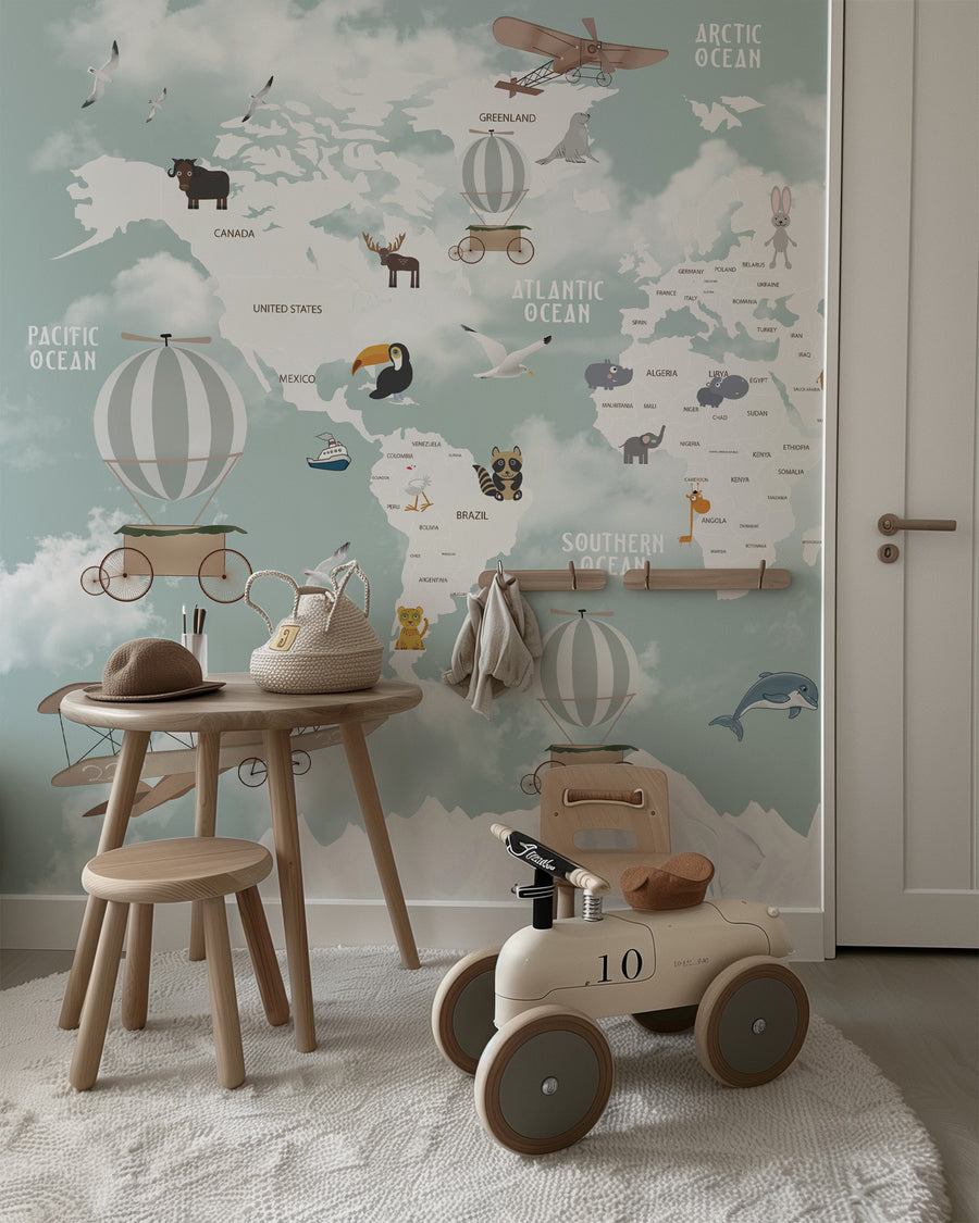 Children's room with Educational world map wall mural in sage green featuring labeled oceans, continents, animals, and vintage airplanes