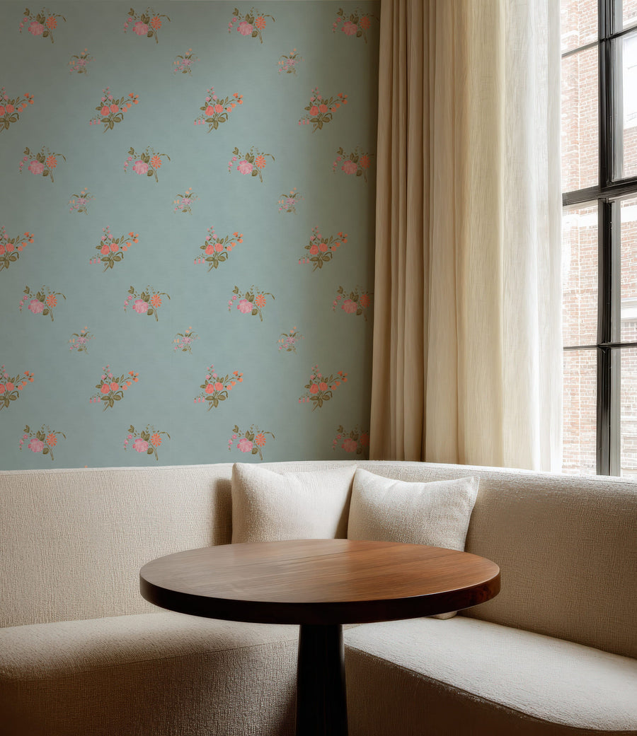 Cozy corner with a beige sofa, wooden table, and Vintage Heirloom Floral Bouquet Wallpaper in Blue
