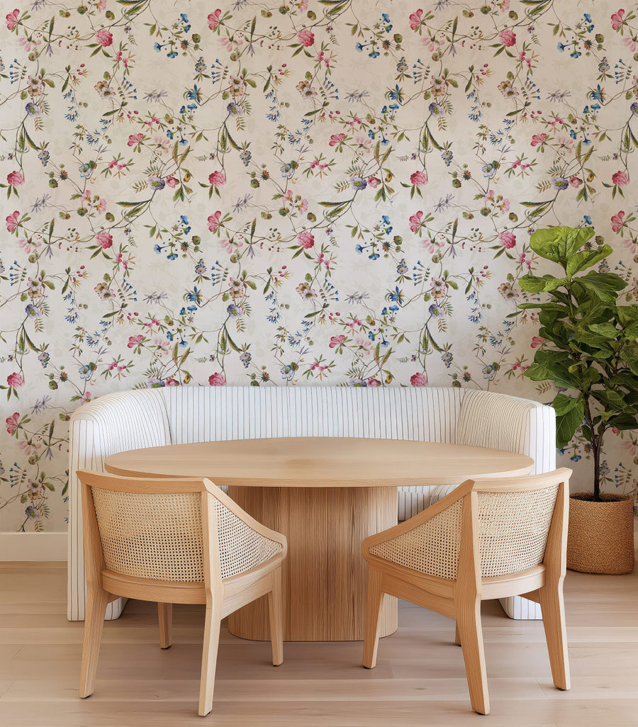 Dining area with wooden table and chairs against a Watercolor Wildflower Wallpaper – Pink, Blue & Green Floral