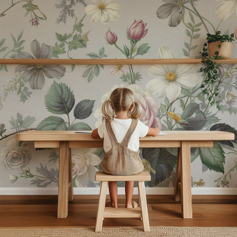 Girl sitting at a wooden table with Vintage Pastel Grey & Pink Botanical Floral Wall Mural in the background