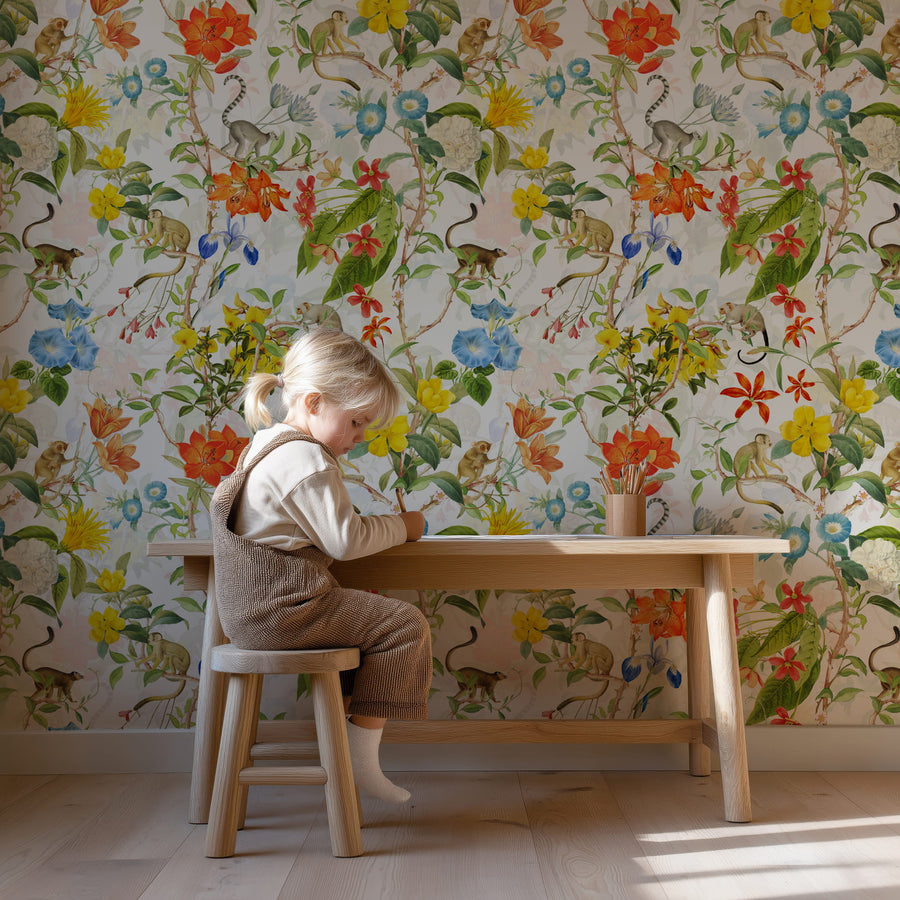 Little girl sitting against the Bright Tropical Wallpaper – Monkeys & Botanical Floral Pattern