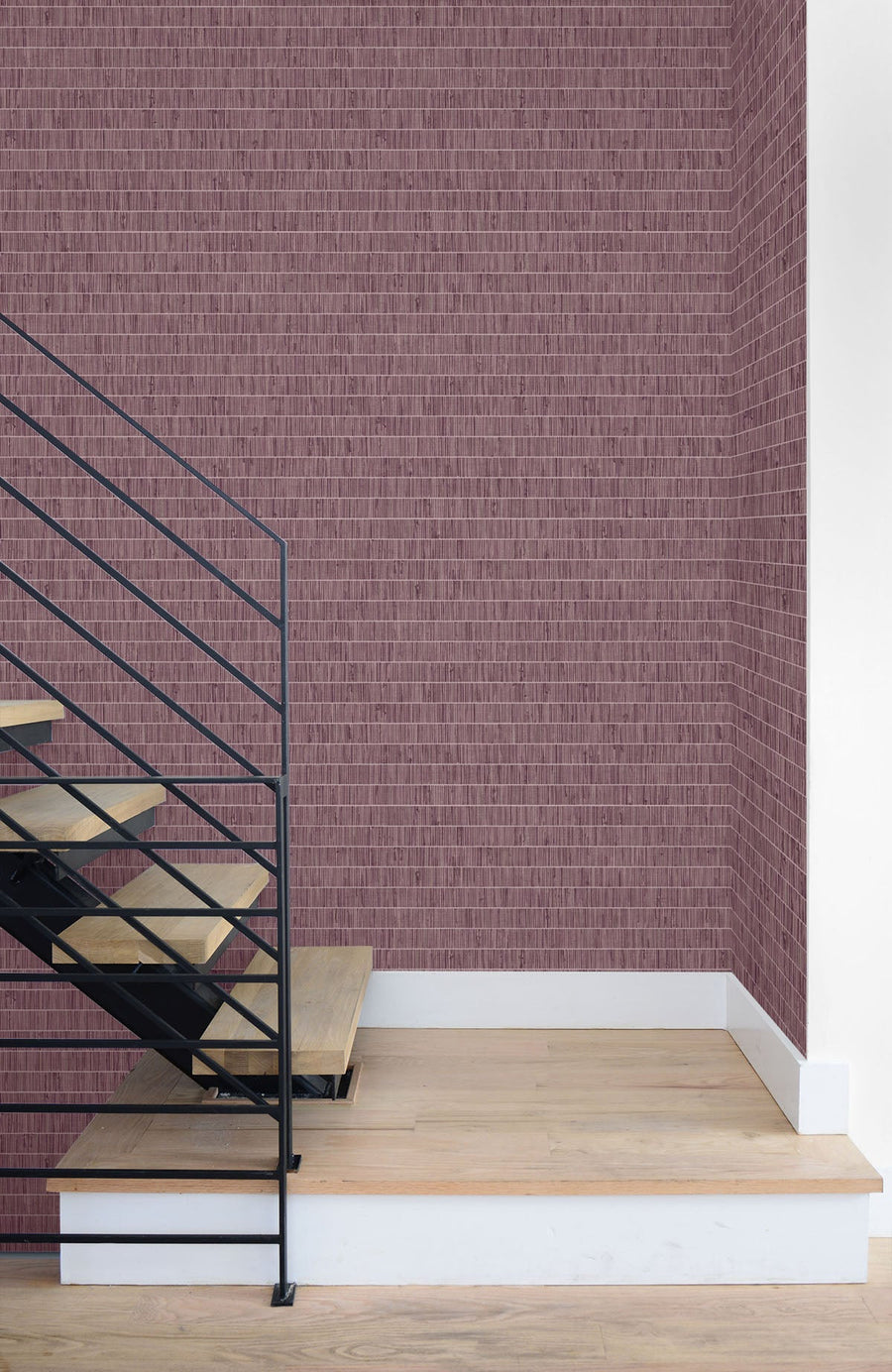 Modern staircase with wooden steps and metal railing against a textured purple wall.