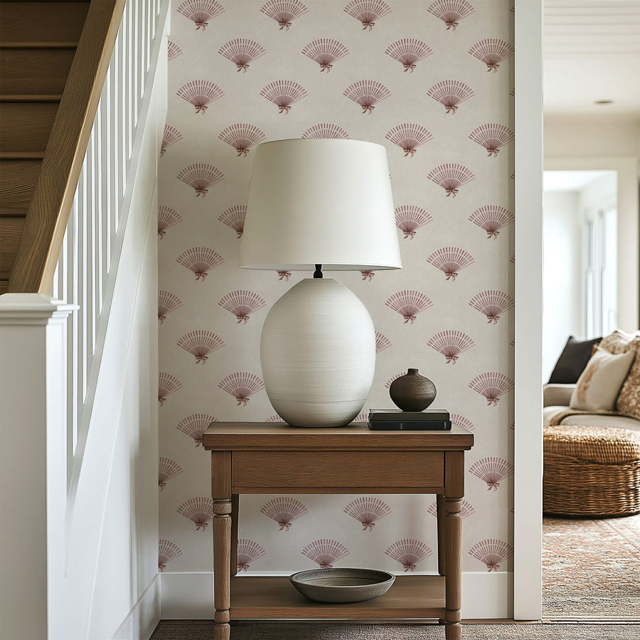 White lamp on a wooden side table against a Neutral Pink Preppy Coquette Bow Fan Wallpaper