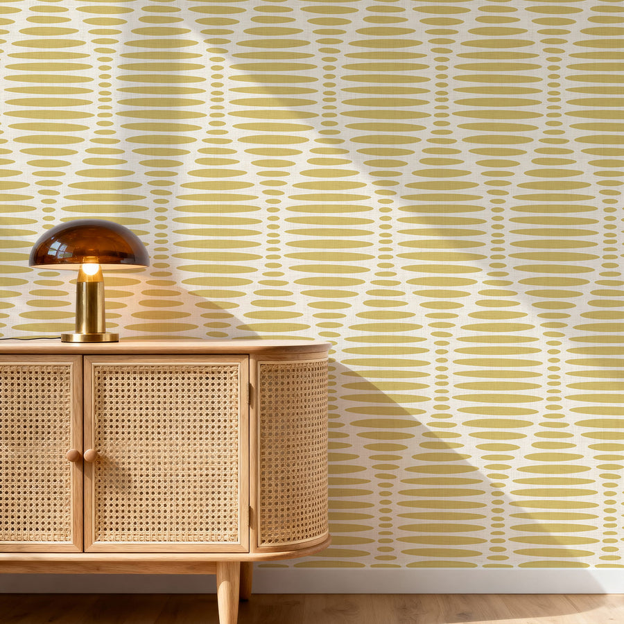 Wooden cabinet with a lamp against a Ogee Sketch Ovals Wallpaper - Mustard Yellow