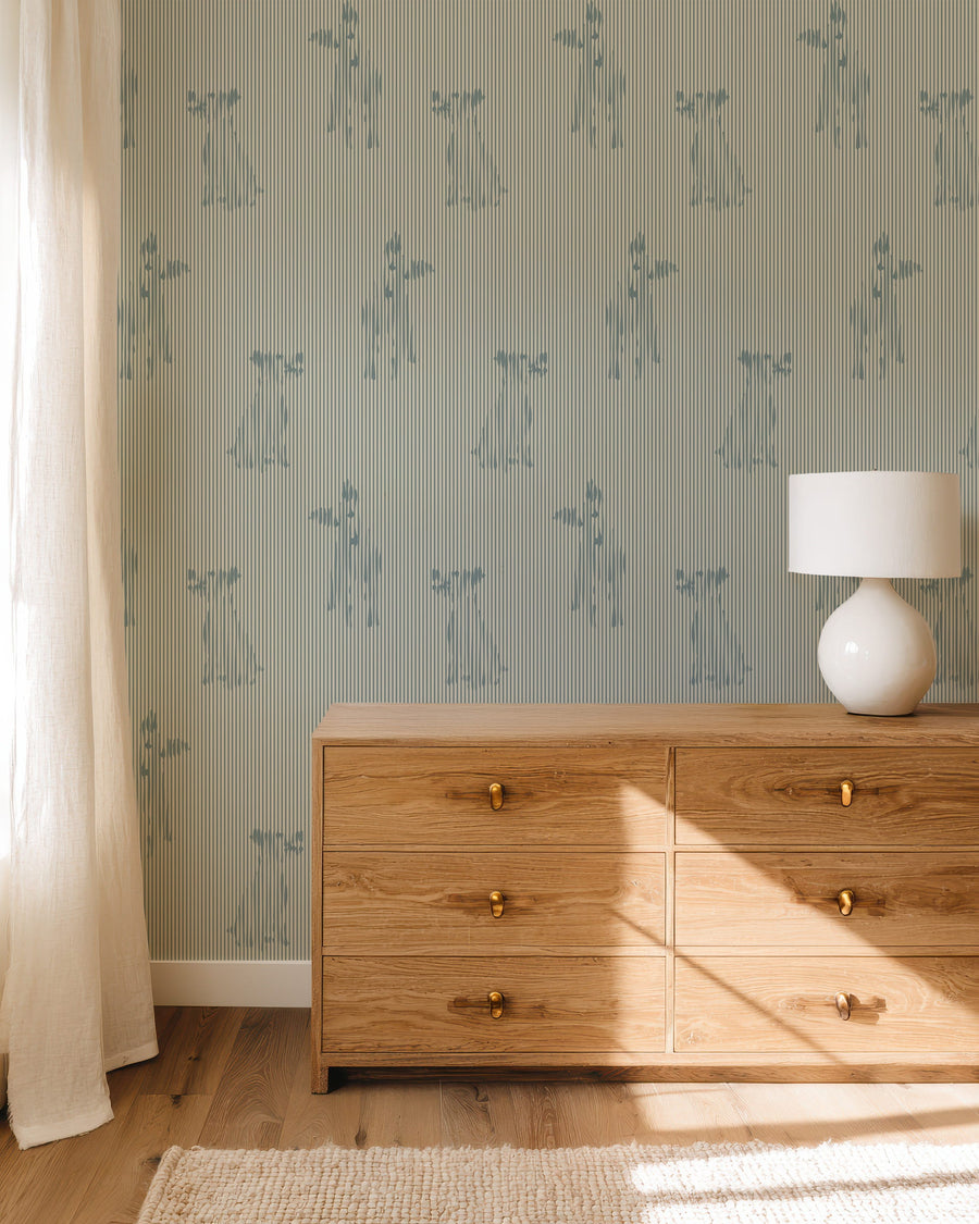 Wooden dresser against a wall with Blue Stripe Playful Dog Silhouette Wallpaper and shelves and a lamp on top