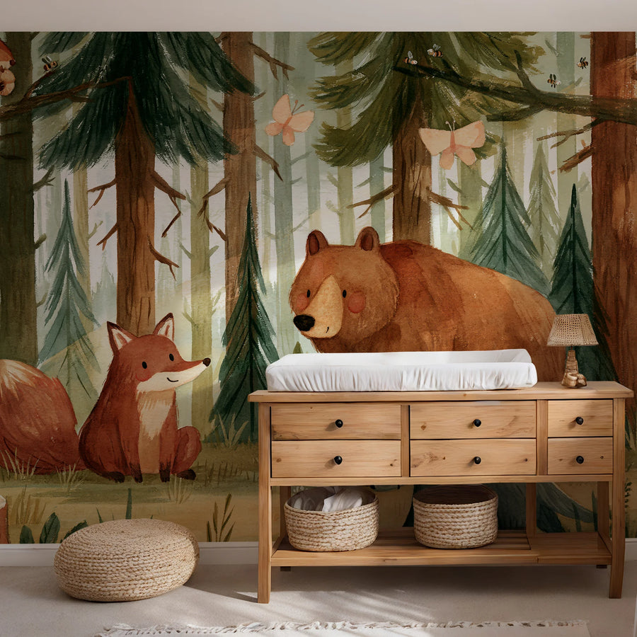 Bear and fox forest wall mural behind a wooden dresser with woven baskets