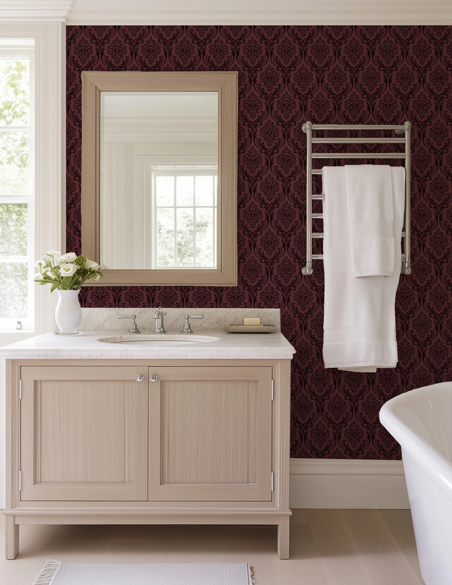 Burgundy damask wallpaper in a bathroom with a wood vanity and mirror