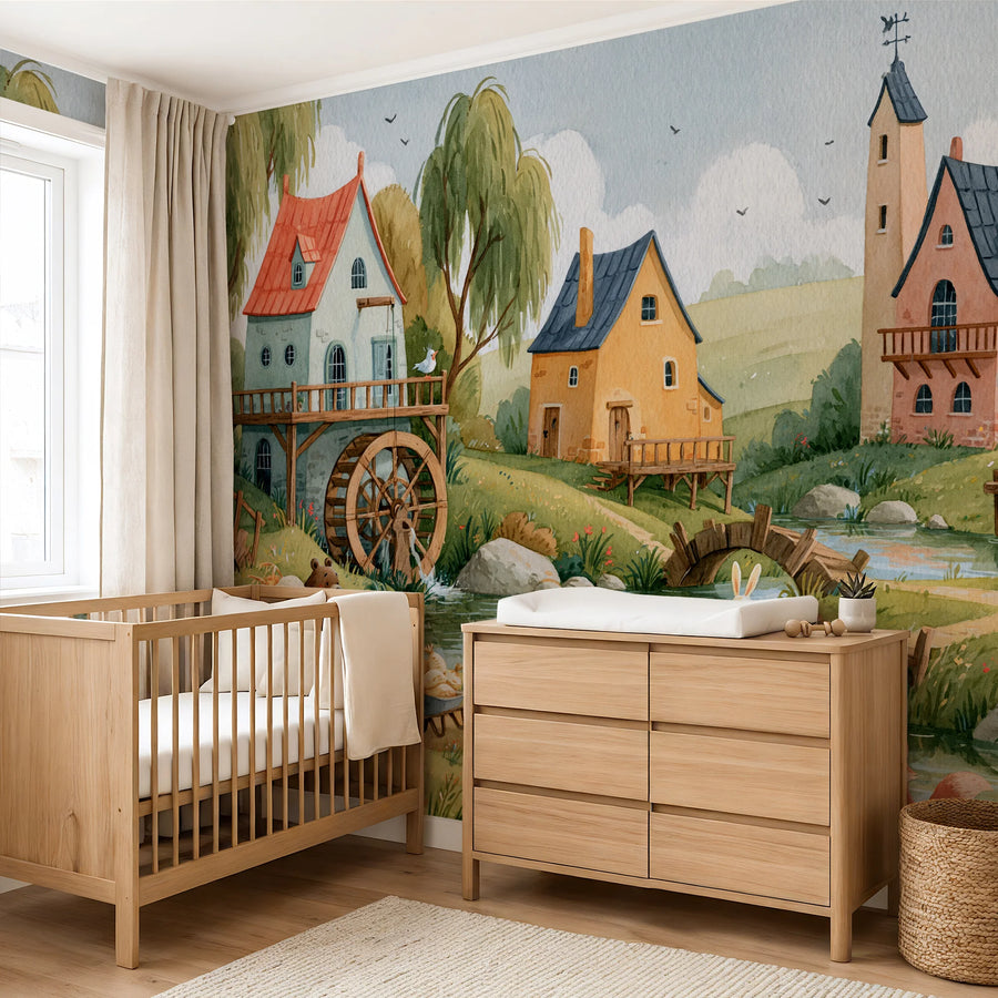 Countryside nursery mural with a watermill and animals behind a wooden crib and changing dresser