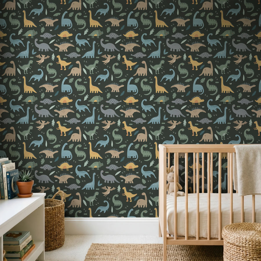 Dark green dinosaur wallpaper for kids behind a wooden crib and low white bookshelf in a nursery