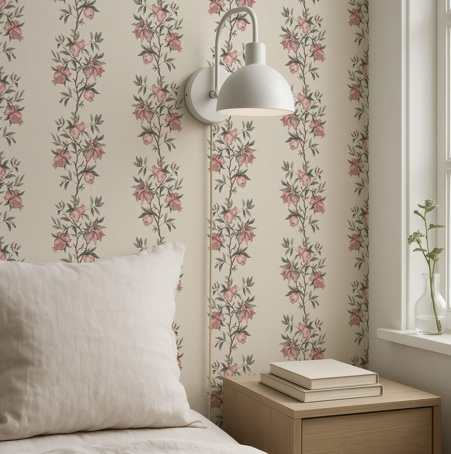 Bedroom with cream pillow stacked books and wall sconce featuring Elodie Chinoiserie Pomegranate Wallpaper Beige accent wall