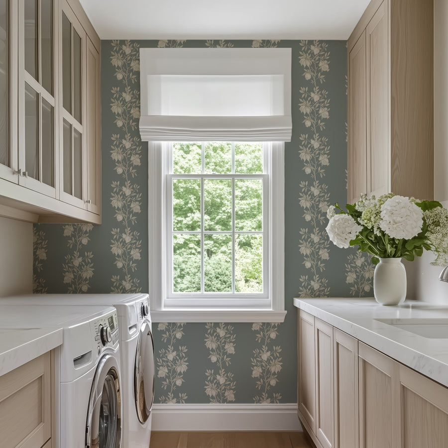 Laundry room with washer cabinets and window featuring Elodie Chinoiserie Pomegranate Wallpaper Muted Blue accent wall