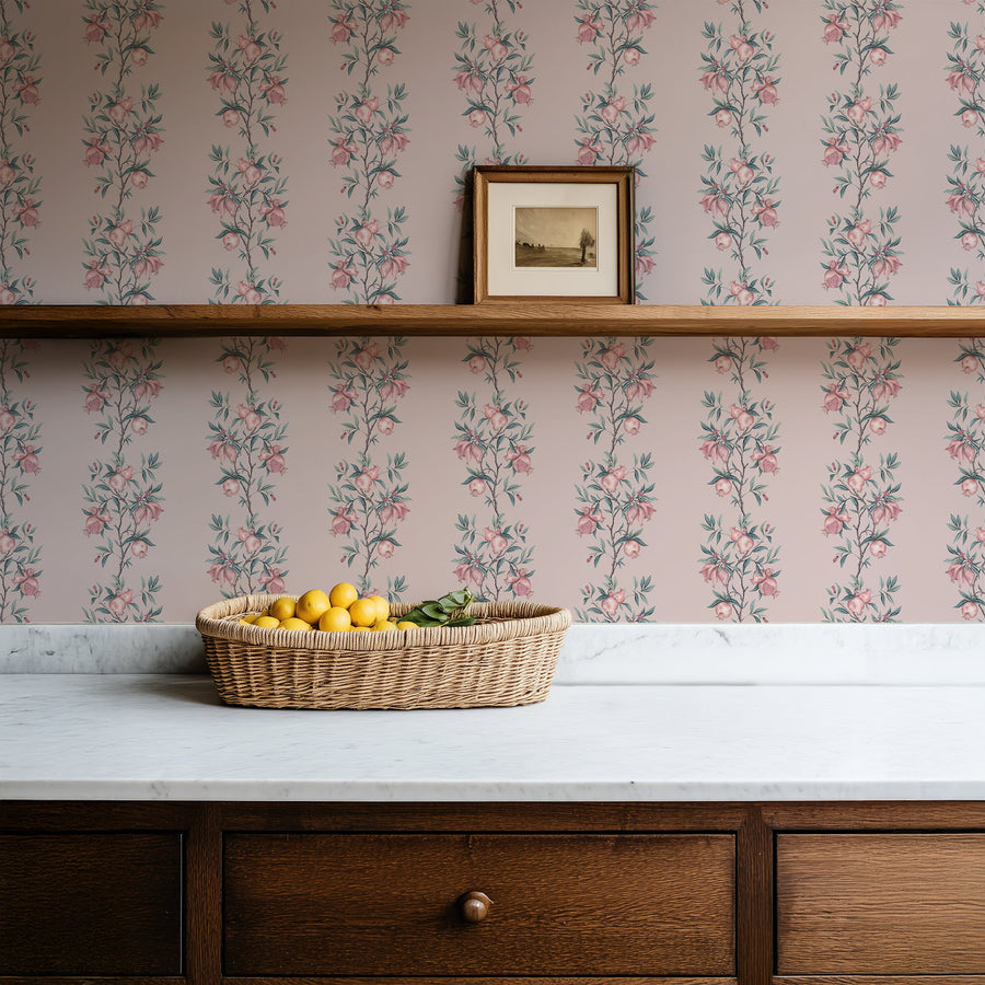 Kitchen counter with fruit basket and drawers featuring Elodie Pomegranate Chinoiserie Wallpaper Pink Sage accent wall