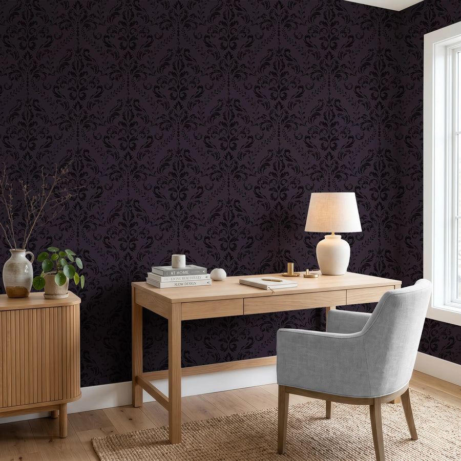 Gothic purple damask wallpaper in a home office behind a wood desk