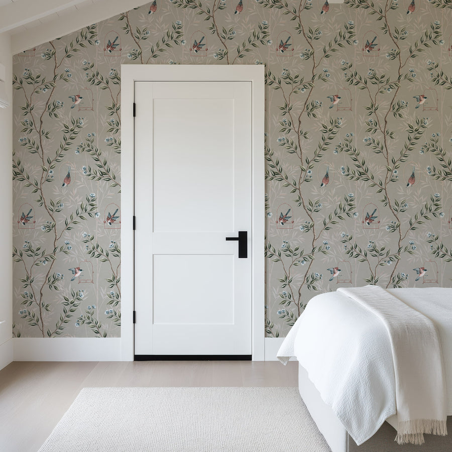 Bedroom with white door and cream bedding featuring Gray Chinoiserie Pauline Wallpaper Birds Branches accent wall