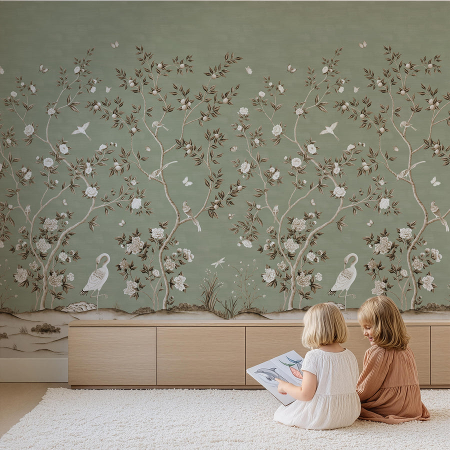 Playroom with two children seated reading in front of Green Chinoiserie Wallpaper Mural Birds Cranes accent wall
