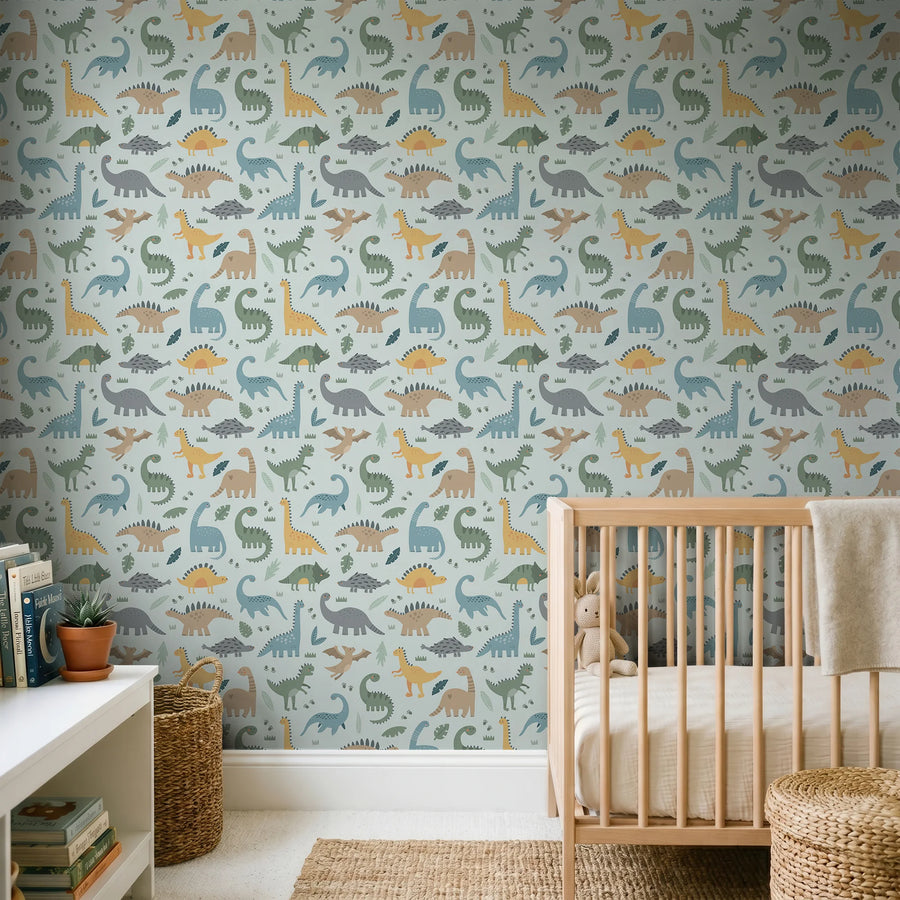 Pastel light blue dinosaur wallpaper behind a wooden crib and white shelf