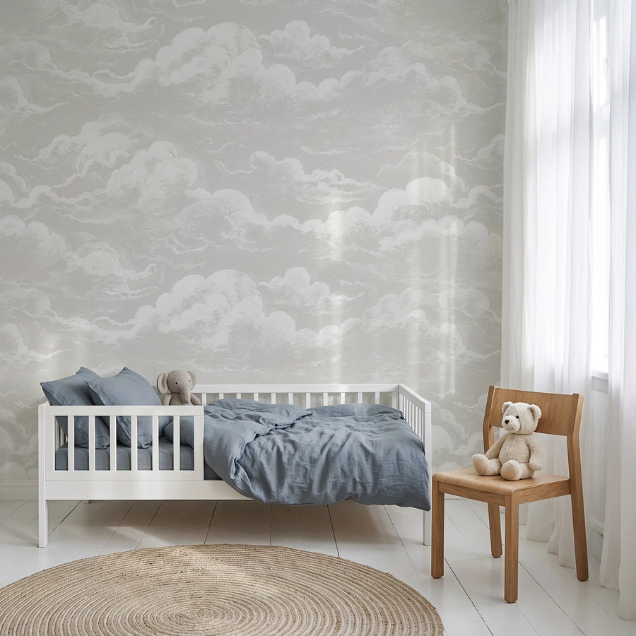 Light grey sky and clouds wall mural in a nursery with a crib