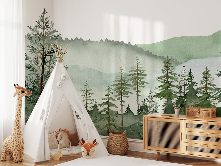 Sage green mountain and pine tree mural in a kids room with a white desk and wooden shelf