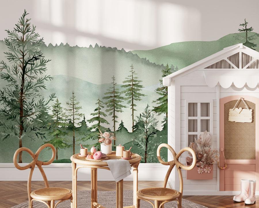 Sage green misty mountain wall mural behind a white playhouse and small table