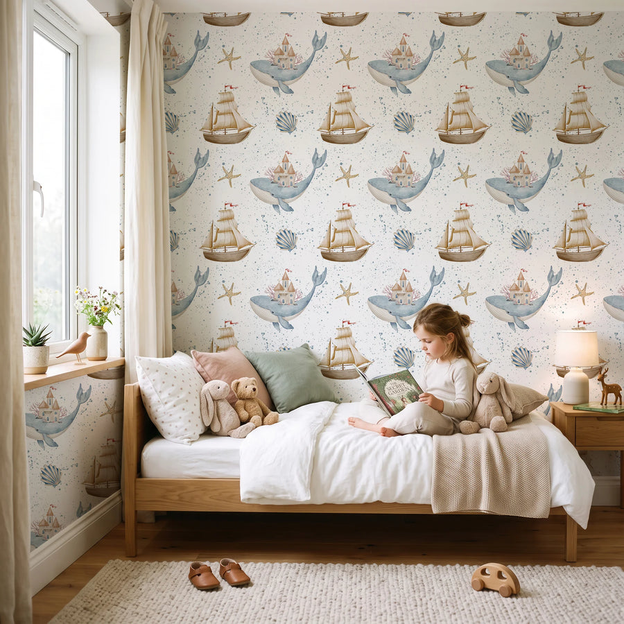 Whale and sailboat nautical wallpaper in a child's bedroom with a daybed and reading nook