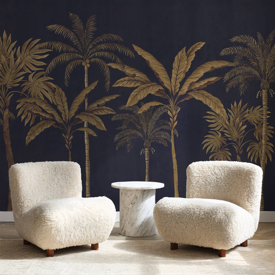 Navy and gold palm tree wallpaper mural behind two cream boucle armchairs