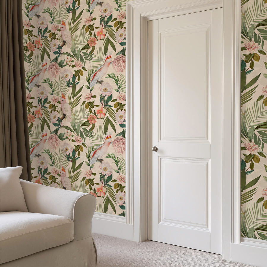 Pink cockatoo tropical floral wallpaper in a room with a cream armchair