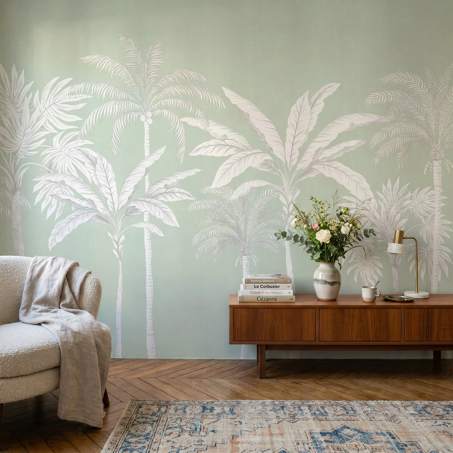 Sage green palm tree mural in a sitting nook behind a cream sofa and throw