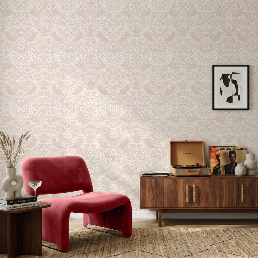 William Morris Strawberry Thief blush pink wallpaper behind a red chair and walnut credenza