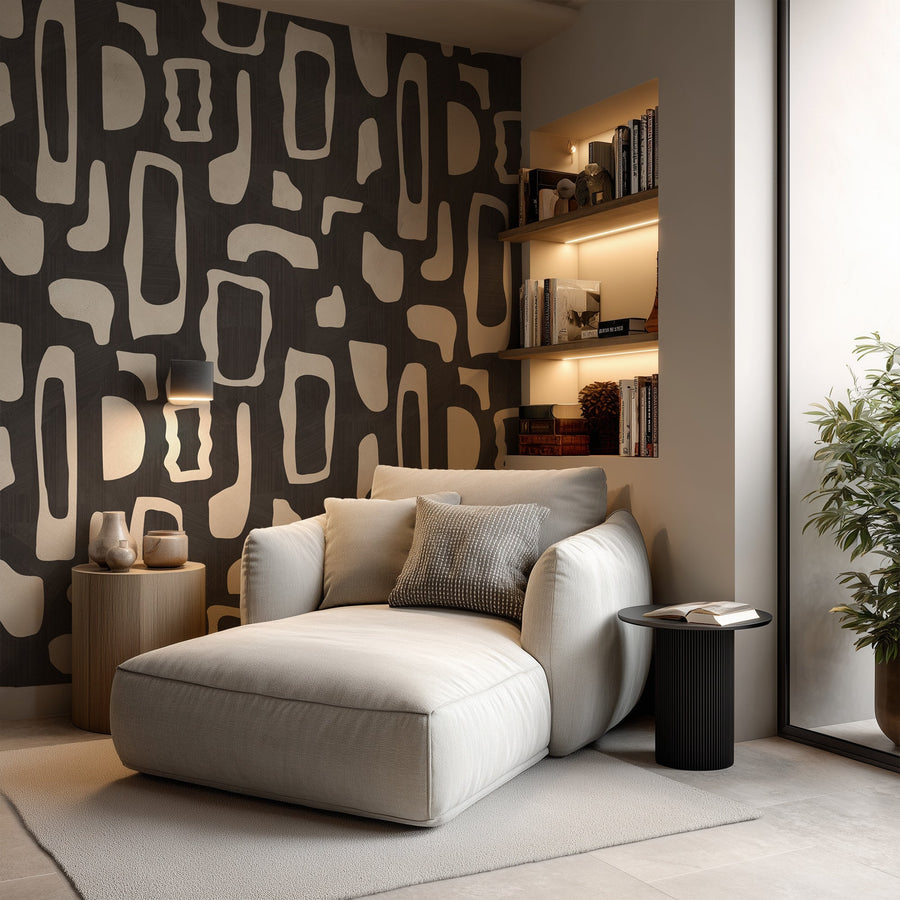 Reading nook with cream curved lounge chair built-in shelves and black side table featuring Abstract Organic Shapes Wallpaper Black Cream by Petra Kohlmayr