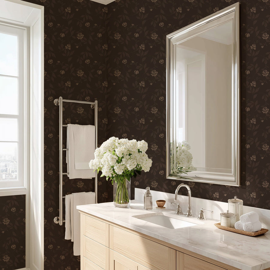 Bathroom with dark floral wallpaper, light wood vanity, and white flowers on countertop.