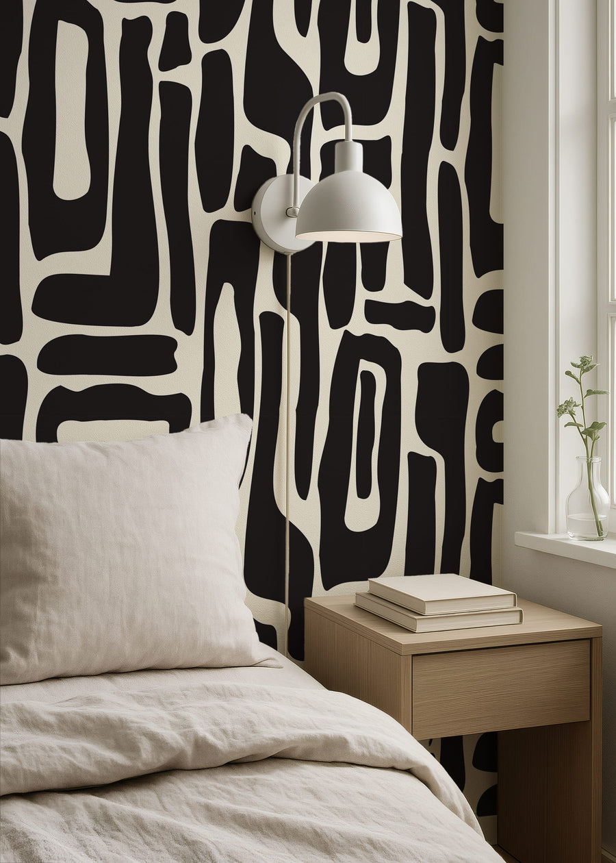 Bedroom with Modern Abstract Black and White Geometric Wallpaper white lamp, and wooden nightstand