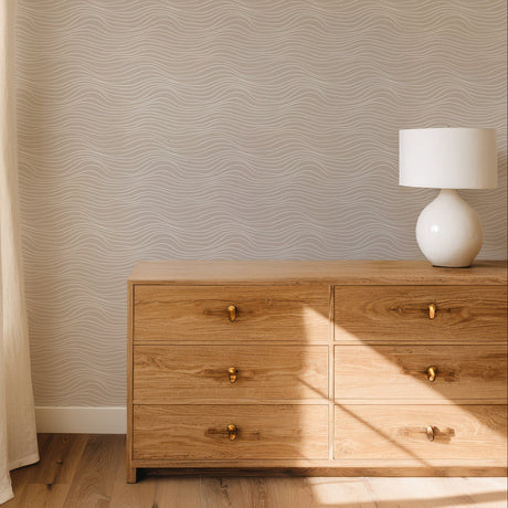 Beige minimalist wallpaper with white wavy line pattern for modern neutral interiors