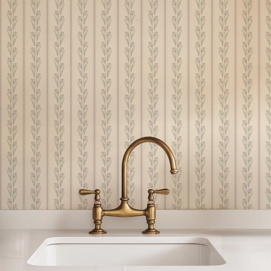 Brass kitchen faucet over a white sink with Cream and Pink Vintage Tulip and Stripe Wallpaper