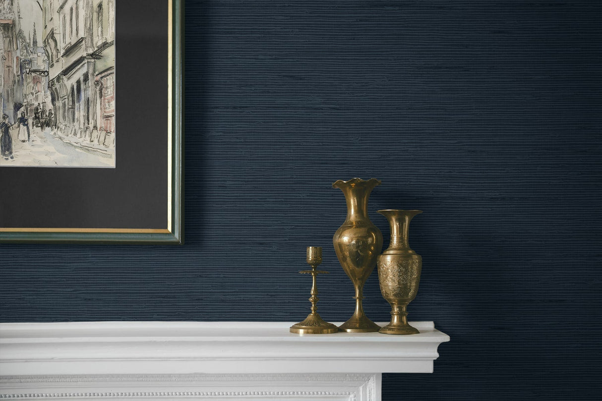 Decorative vases on a white mantelpiece against a dark blue wall with framed artwork.