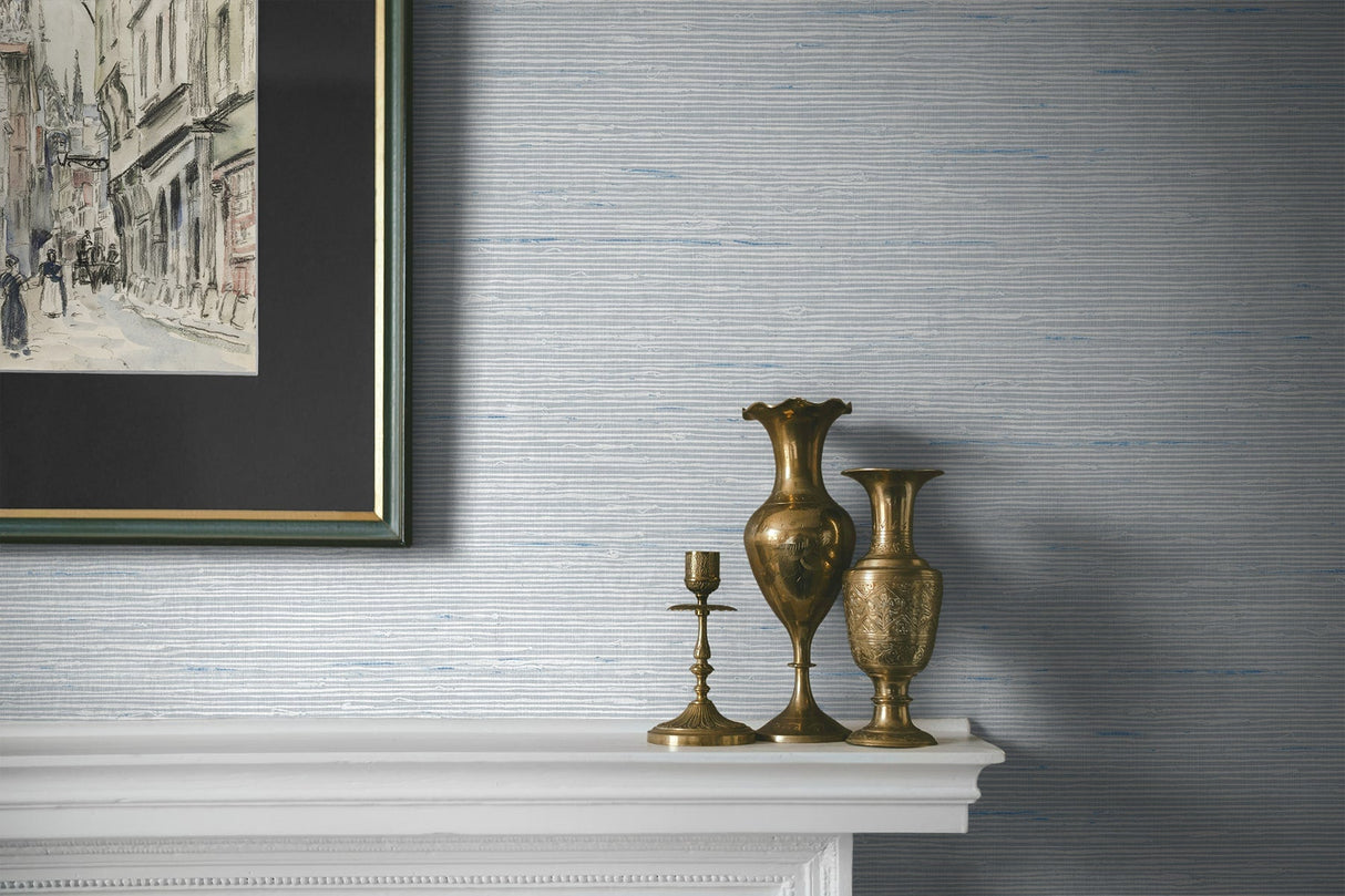 Decorative vases and candlestick on a mantelpiece with a framed artwork above.